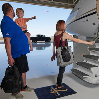 couple with child getting on a airplane with beautiful backdrop.