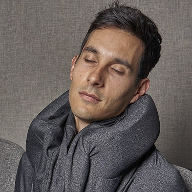 Brunette Male model wearing sloodie sleep hoodie in an airport seat waiting and resting