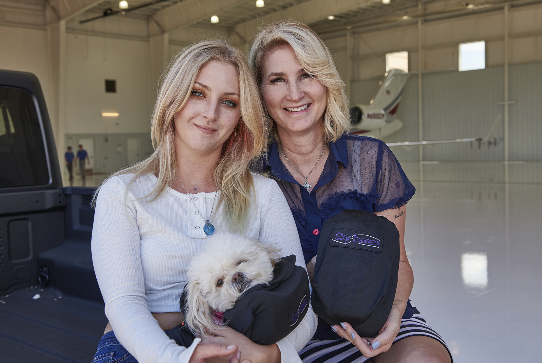photo of two sloodie customers and fans inside a plane hanger
