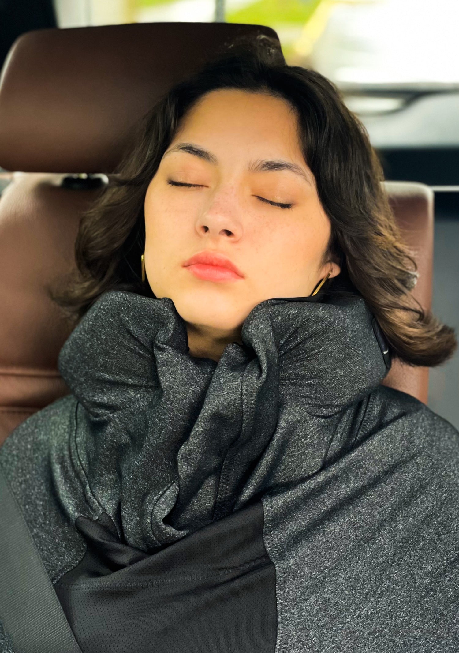 charcoal color sleep hoodie being worn in car by young female model sleeping