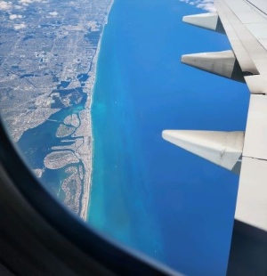 view out the plane window at the coastline