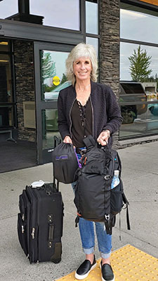 A grown woman with her bags waiting outside the airport