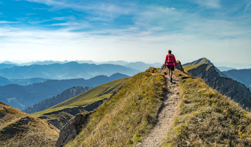 A woman hiking atop a mountain range